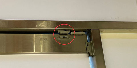 Magnetic lock installed on a metal office door with a door position sensor.