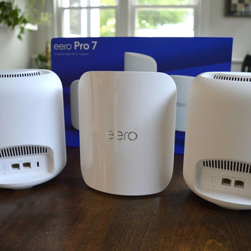 Eero mesh Wi-Fi system with multiple nodes on a desk and bookshelf