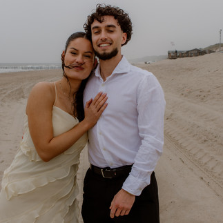 man vraagt vrouw ten huwelijk tijdens fotoshoot op het strand