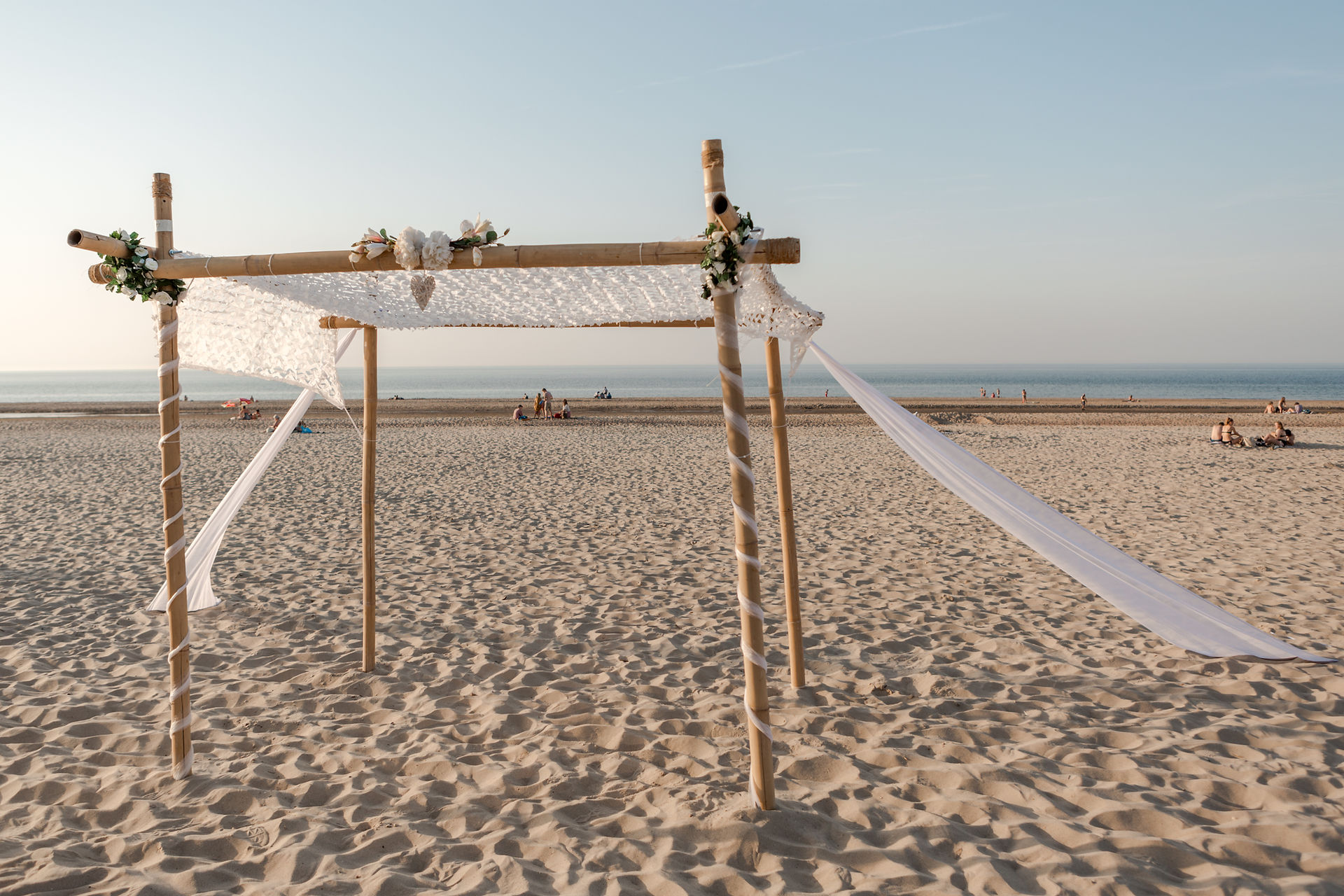 Bruidspaar tijdens een strandbruiloft in Zeeland met uitzicht op zee