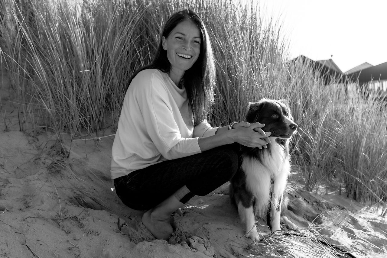 Vrouw met hond op het strand in Cadzand tijdens het gouden uur