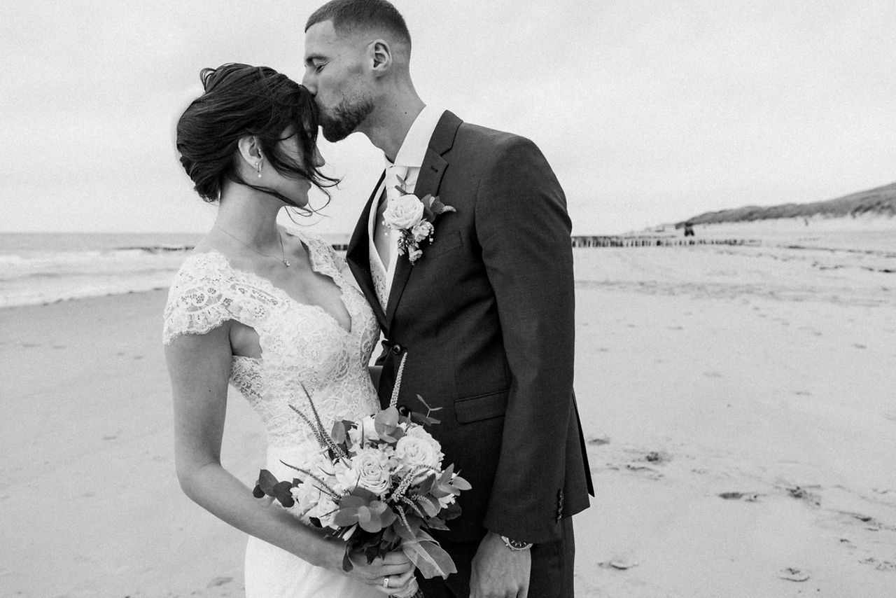 zwart wit foto van bruidspaar op het strand van vlissingen door irene van de wege, bruidsfotograaf