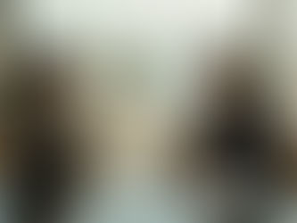 Des collègues échangent autour d’une table dans un espace de travail partagé baigné de lumière.