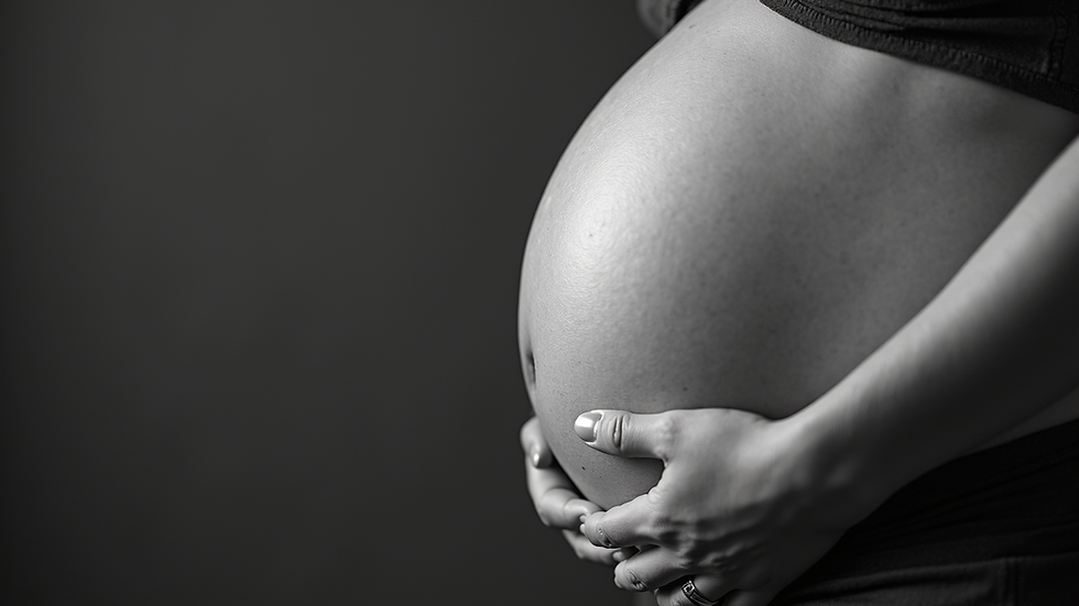 Vue rapprochée d'un album photo ouvert montrant des images de grossesse en noir et blanc