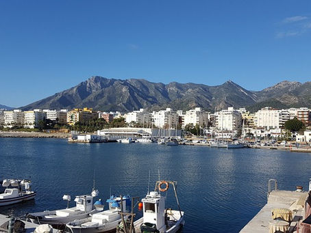 The harbour of Marbella photographed from the sea with the city in the background.