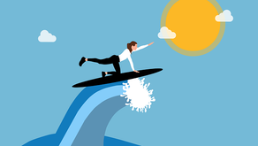 A woman is riding a wave while reaching for the sun