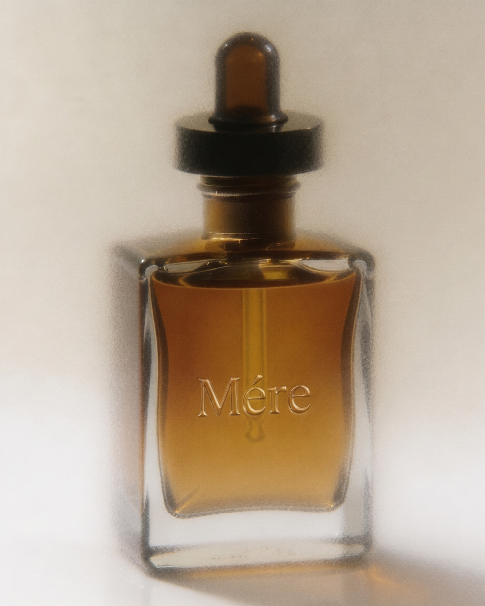 Elegant perfume bottle labeled "Mère" on white background.
