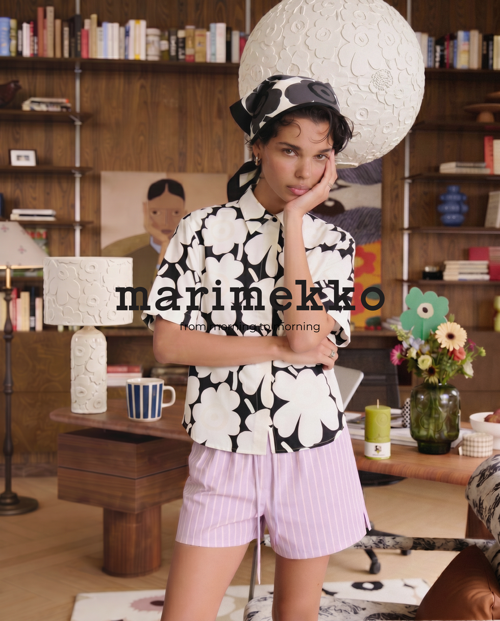 Model in floral outfit in stylish room setting.