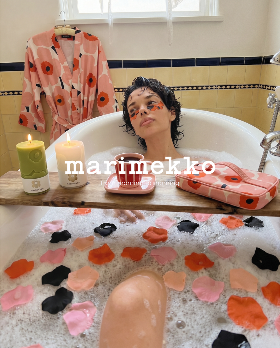 Person relaxing in bathtub with colorful petals.