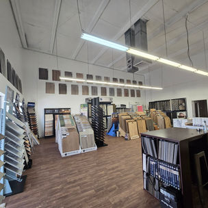 Elegant luxury flooring showroom interior with organized displays of carpet and hardwood.