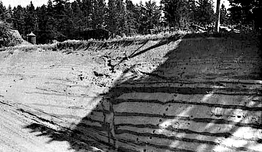 Willamette Valley rhythmites. Graded beds nearly identical to the Touchet Beds of south-central Washington are present in Willamette Valley, OR. Dark layers are the coarse-grained lower portions of each bed. Clastic dikes are relatively sparse in these slackwater deposits. A clastic dike is seen cutting steeply through the stack at the center of the photo. To the left is a line of steps cut into the slope by the geologist to allow closer inspection of the exposure, a common practice. Photo by Allison (1978, Fig. 14) taken about five miles southeast of St. Paul, OR.