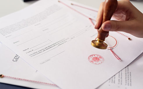 Close up on woman's notary public hand ink stamping the document. Notary public concept.jp