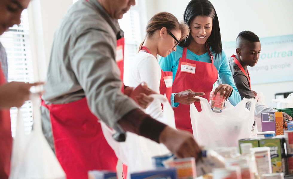 Volunteers of all ages packing bags of food to support local families in need.