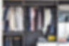 modern closet with row of cloths hanging in black wardrobe.jpg