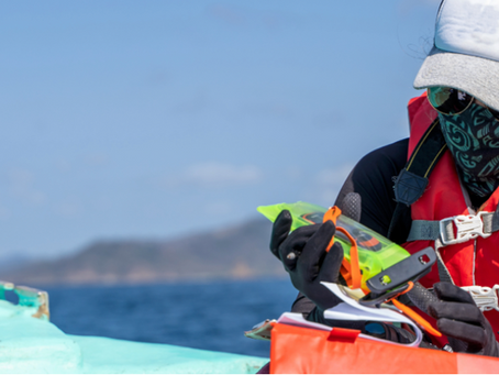 “Marine researcher on a boat handling ocean monitoring equipment during a field research project at sea.”