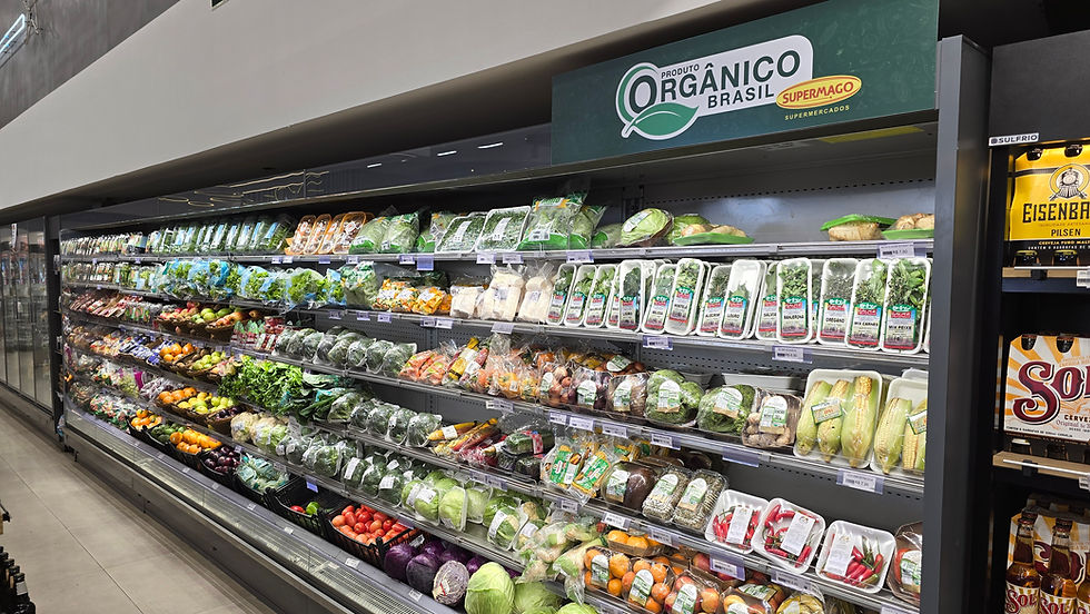 Corredor de hortifruti no supermercado, com frutas e legumes orgânicos embalados e placa Produto Orgânico Brasil.