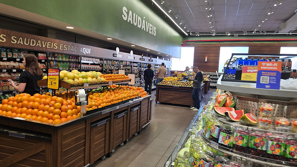 Corredor de supermercado com frutas frescas, clientes escolhendo produtos e placas de promoção e Saudáveis.