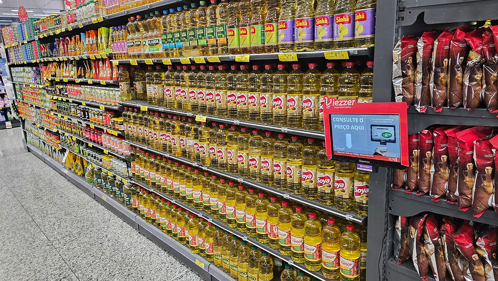 Corredor de supermercado com fileiras de óleos de cozinha e pacotes; placa digital Viezzer mostra consulte o preço aqui.