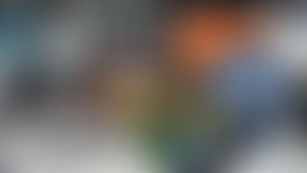 Homem sorri e pesa uvas verdes em balança Urano B40, em estande de feira com placa Espaço Fresh e frutas ao fundo.