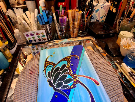 Hand-painted butterfly cremation urn featuring a blue, turquoise, black, and gold butterfly on a contemporary wooden memorial urn