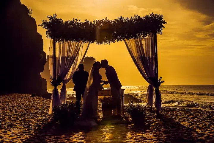 Sunset beach ceremony for a destination wedding. Soft draping, golden light, and intimate vows planned and coordinated from start to finish.