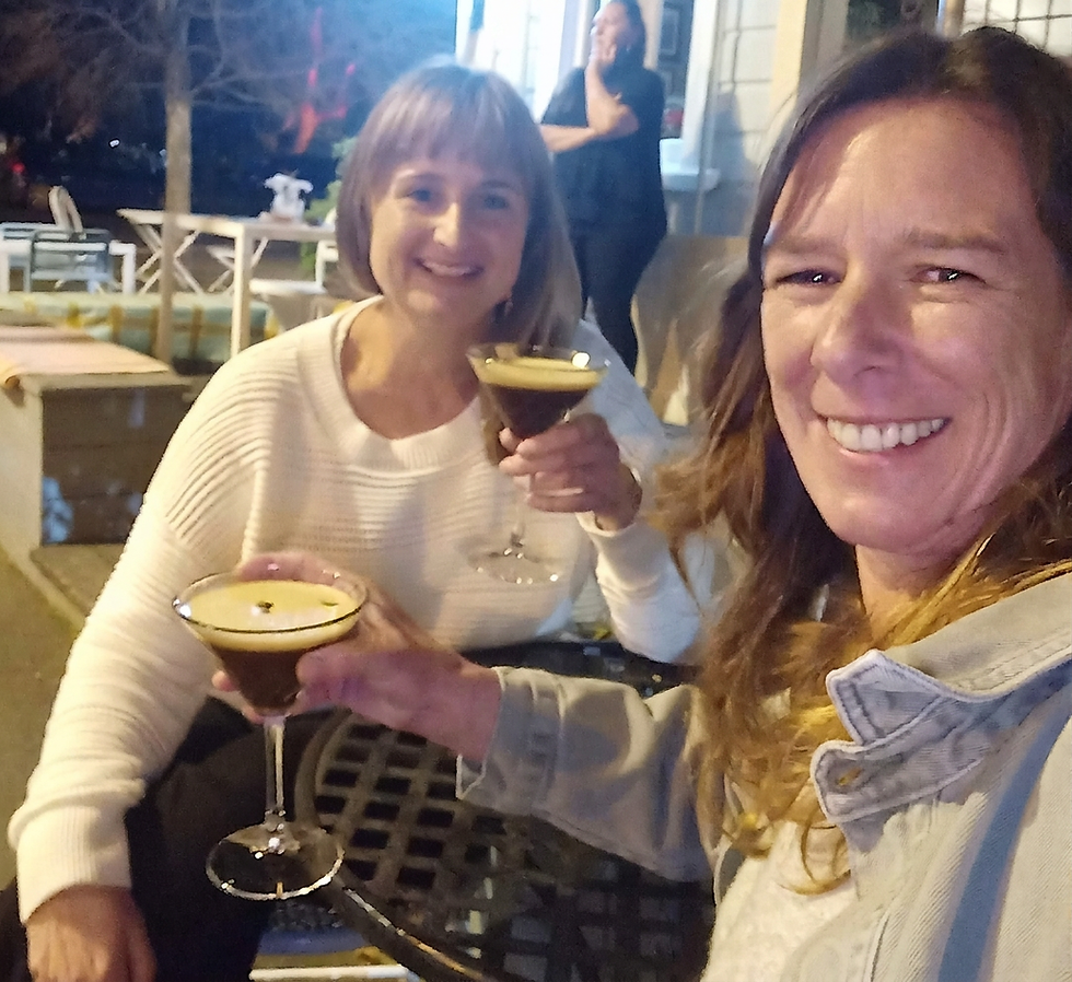 Packshot photography of two women toasting with espresso martinis outdoors. They are smiling and enjoying a casual evening together.