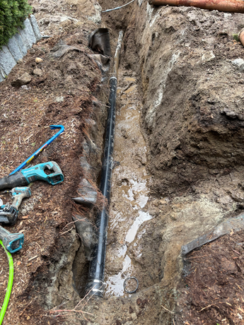 Before picture of a garden showing dirt and a pipe