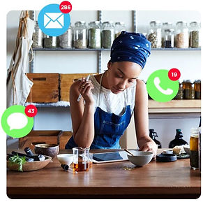 Female Business Owner at her desk working on an smart tablet with message Icons floating around her head