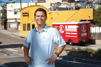 A photo of the founder of GUAC Taco: Bill Graw, standing in front of El Gringo Mexican Restaurant with the GUAC Taco truck parked in front.