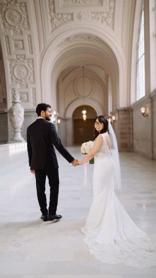 Bride and groom walking through San Francisco City Hall with natural bridal makeup and hair by AN Artistry.
