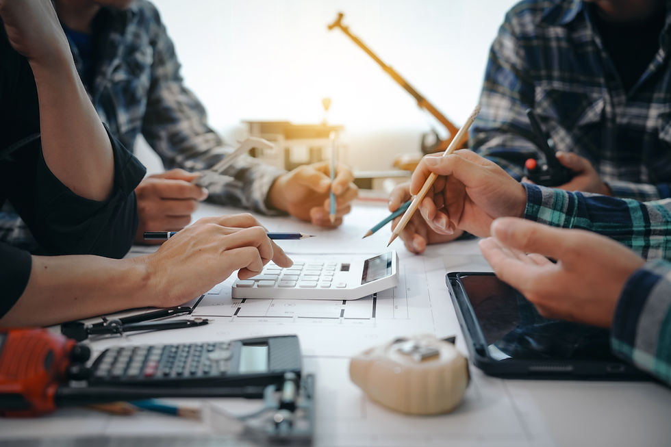People in plaid shirts discuss over blueprints, using a calculator and pencils. A warm, collaborative atmosphere with muted colors.