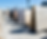 Stone slabs in various colors and patterns are displayed in an outdoor showroom under a clear blue sky. Labels indicate types of granite.