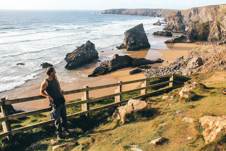 A walker admires Bedruthan Steps