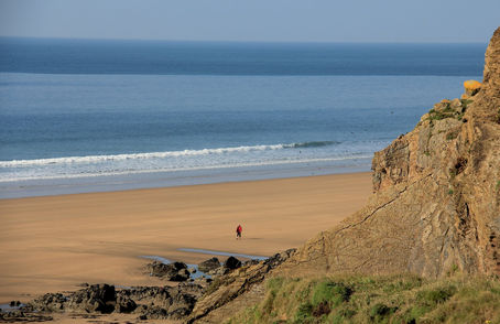 A lone walker on the beach at Sandymouth, north Cornwall