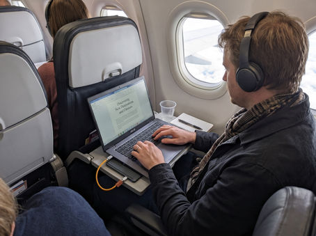 A travel writer using the Krafted Edge power unit on a plane