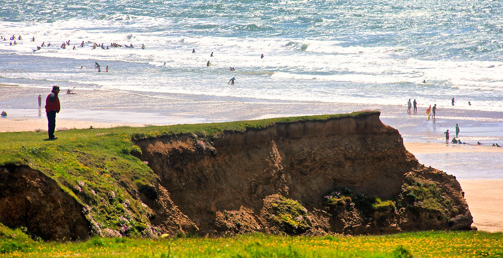 A walker surveys the scene across Bude's northern beaches