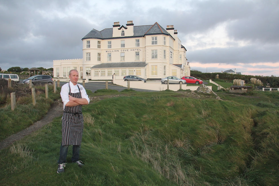 A chef stands in fron of the Mullion Cove Hotel