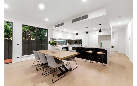 Open-plan kitchen and dining area with timber flooring and natural light