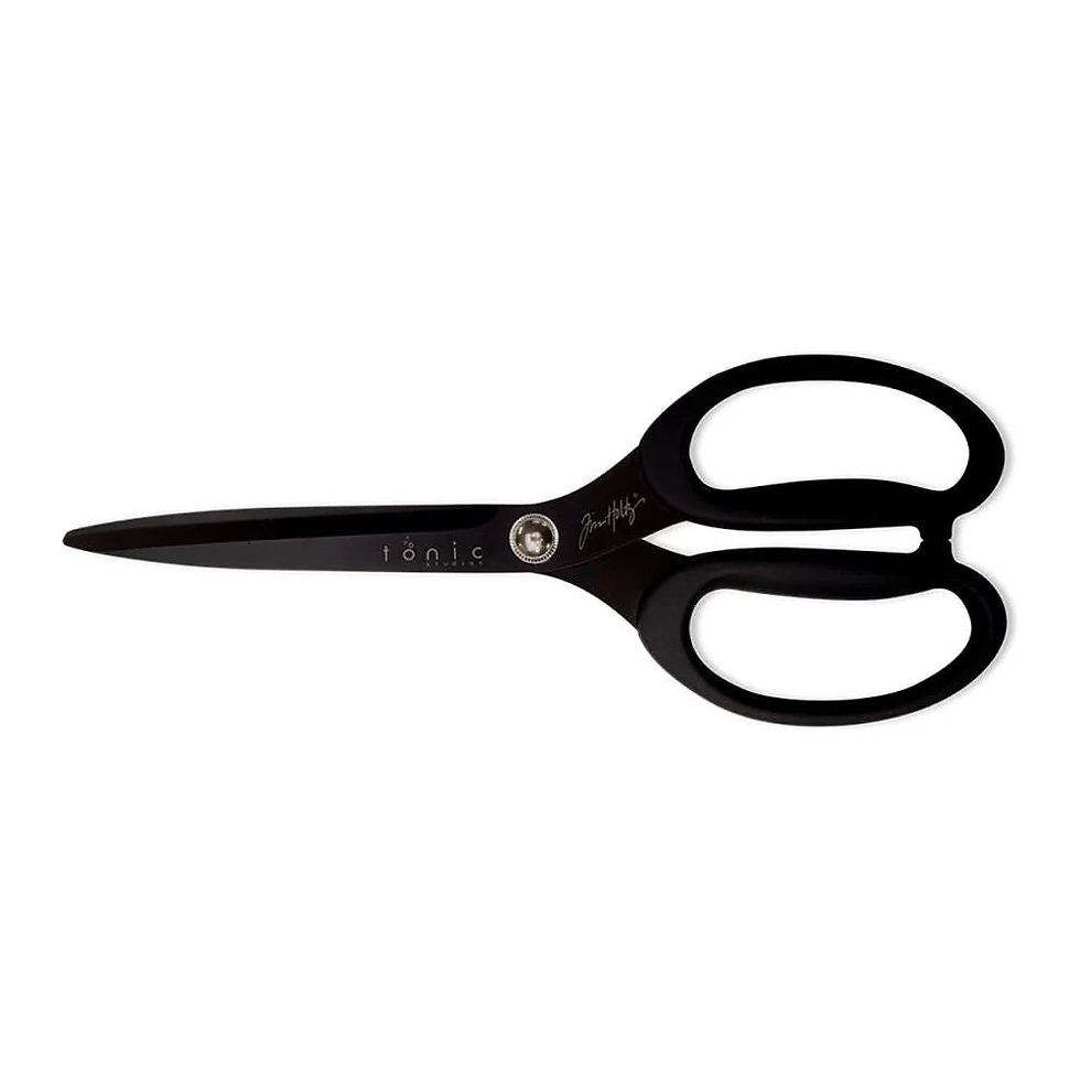 Large titanium craft scissors with serrated edge cutting handmade paper in studio