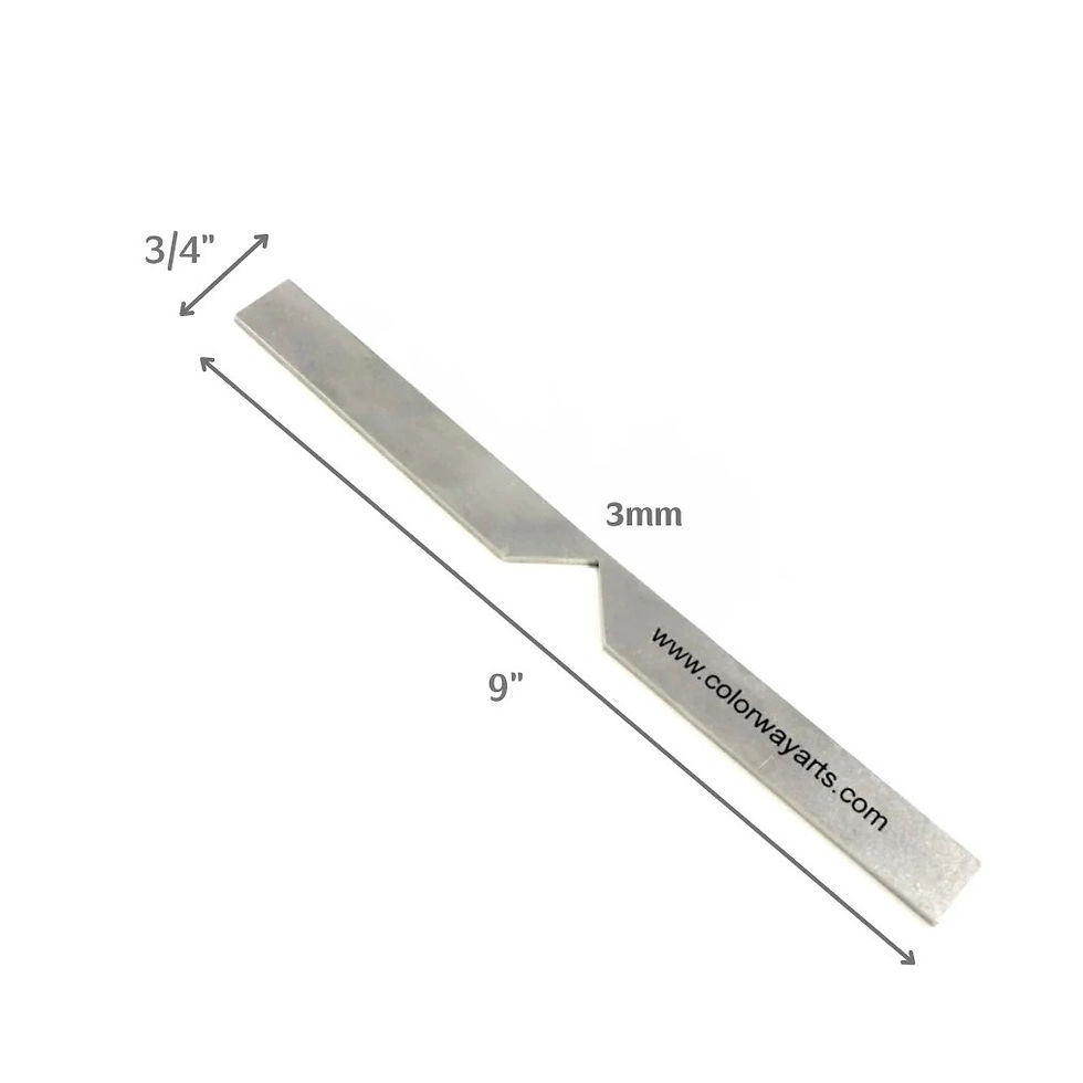 Stainless steel trim and miter tool placed next to handmade book materials on a workbench