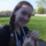 Tour Guide Alessandra Kite smiling with her first banded bird in hand, a Black-capped Chickadee, at Haldimand Bird Observatory.