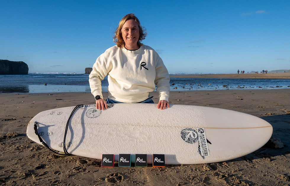 kate from rad wax with a surfboard at Perranporth beach in cornwall
