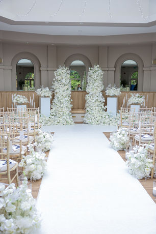 Wedding ceremony aisle styling at The Orangery, Maidstone: white floral arrangements lining the aisle toward the arch, by Cloud Sixty Events
