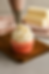 Buttercream being piped onto a cupcake.