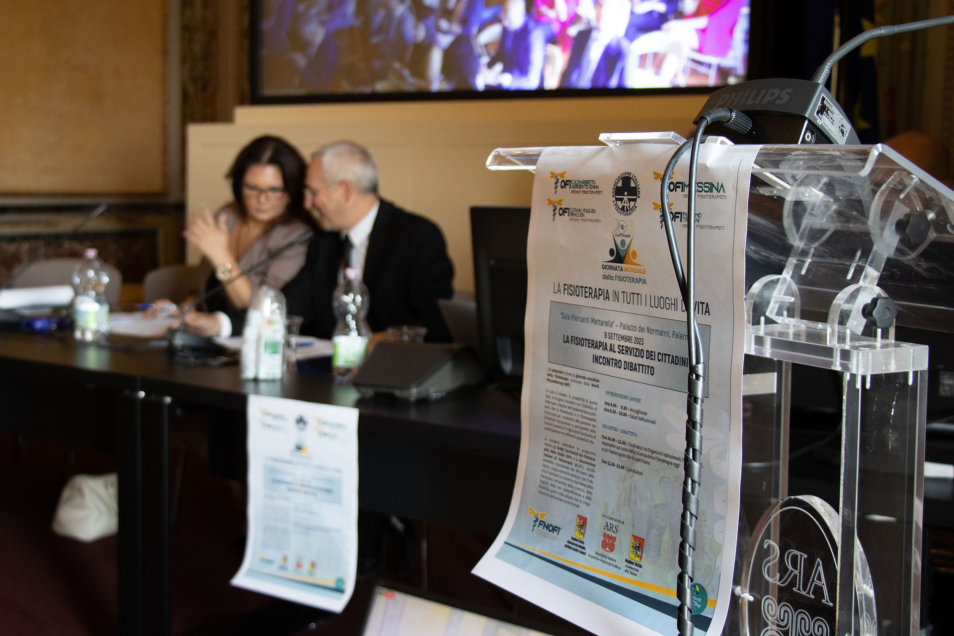 Evento Fisioterapia cittadini, relatori al tavolo con poster