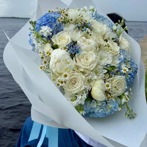 A light and airy mix of white and soft blue flowers, evoking the calm beauty of the sky.