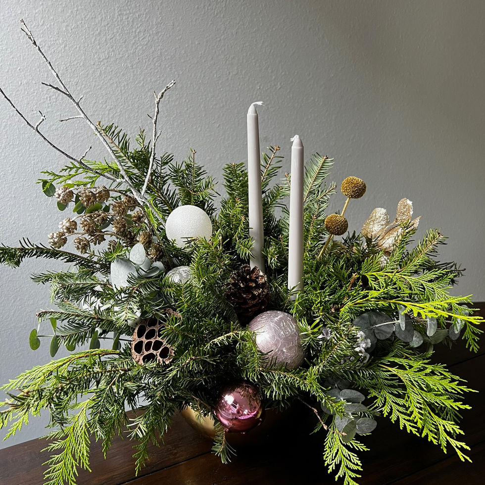 elegant Christmas centerpiece is designed with fresh evergreen branches, winter textures, and soft neutral accents for a refi