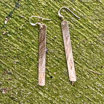 Silver earring on cement background.