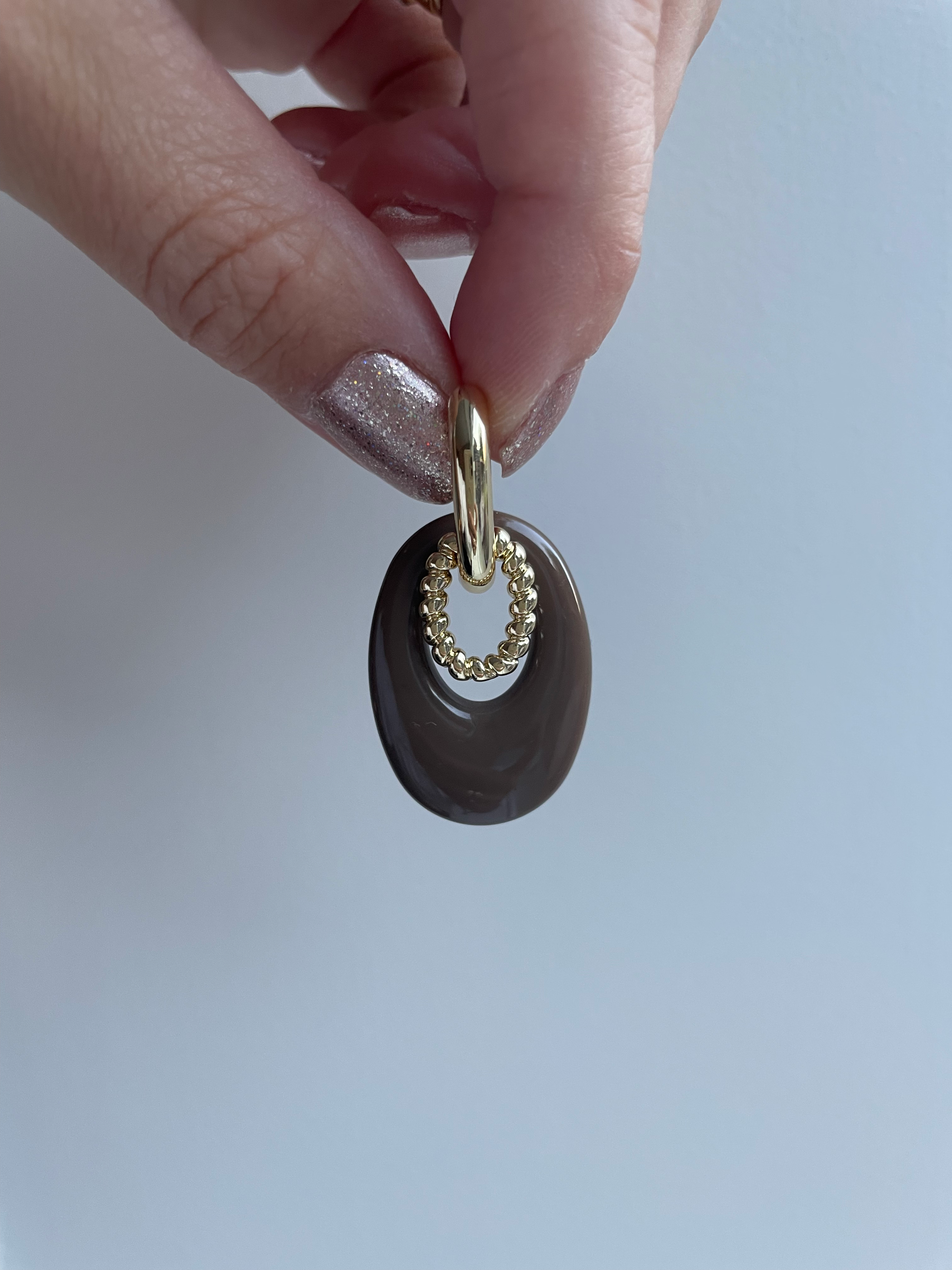 Oorbellen gouden ring met bruin en gouden bedel