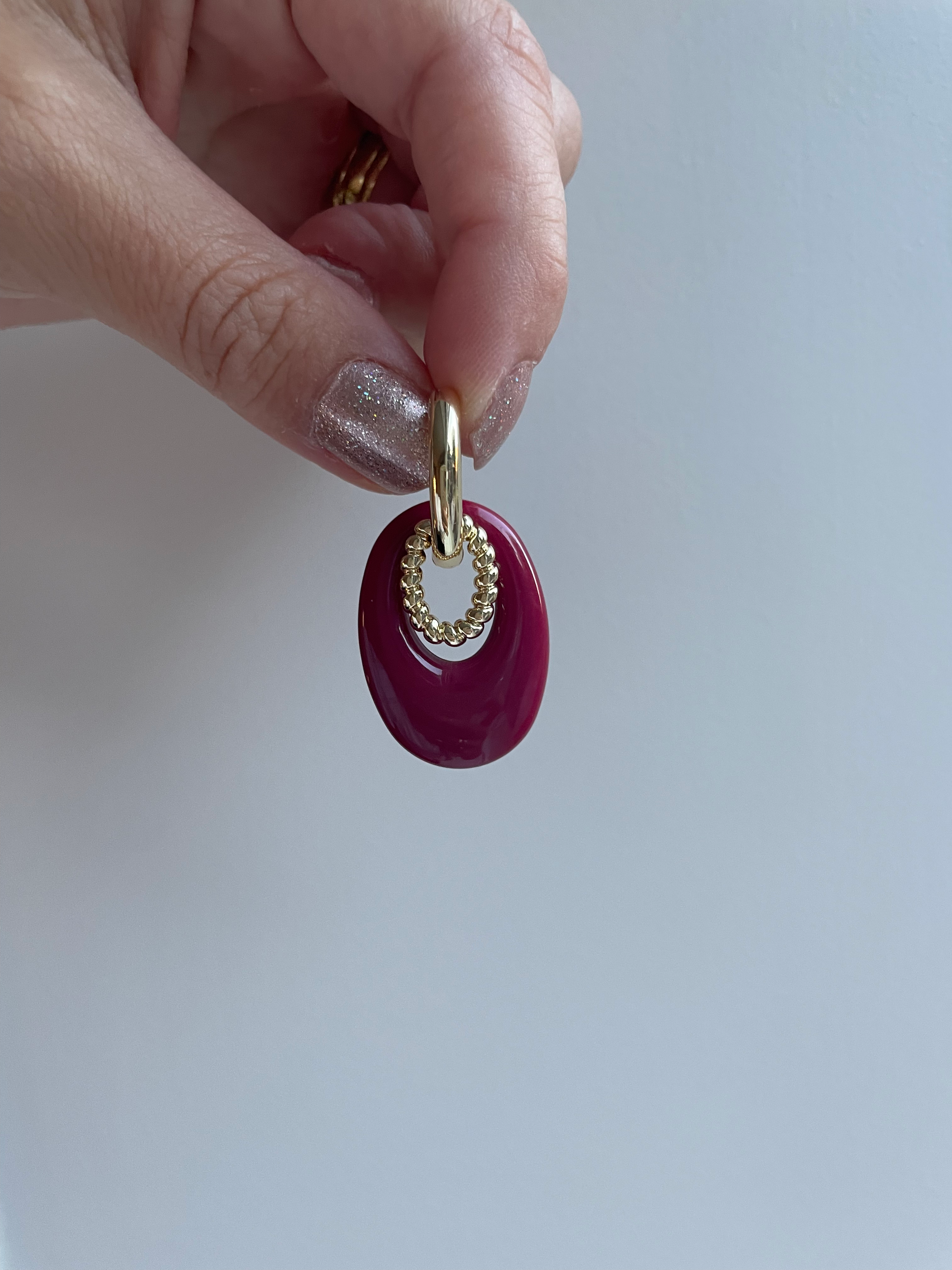 Oorbellen ovalen ring met rood en gouden bedel
